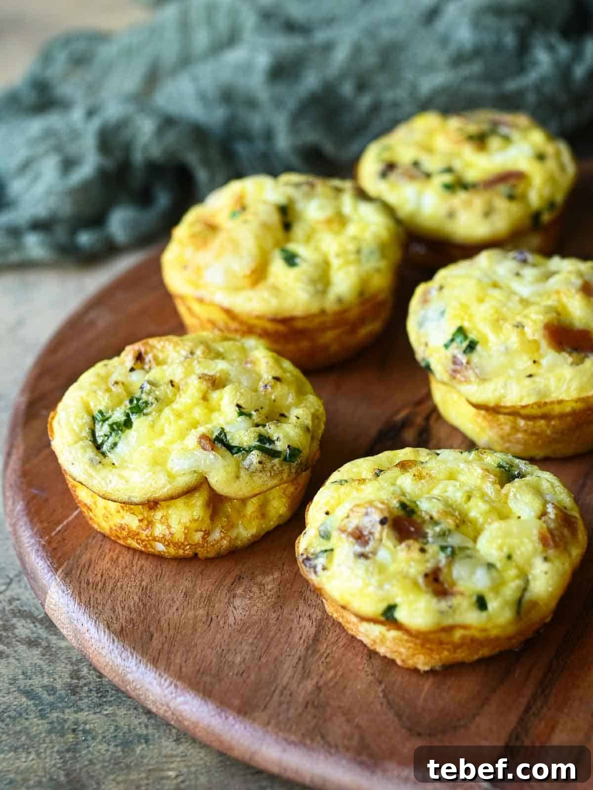Buttermilk Bacon and Egg Bites Recipe for Brunch or Meal Prep 8 Five egg bites on a wood board.