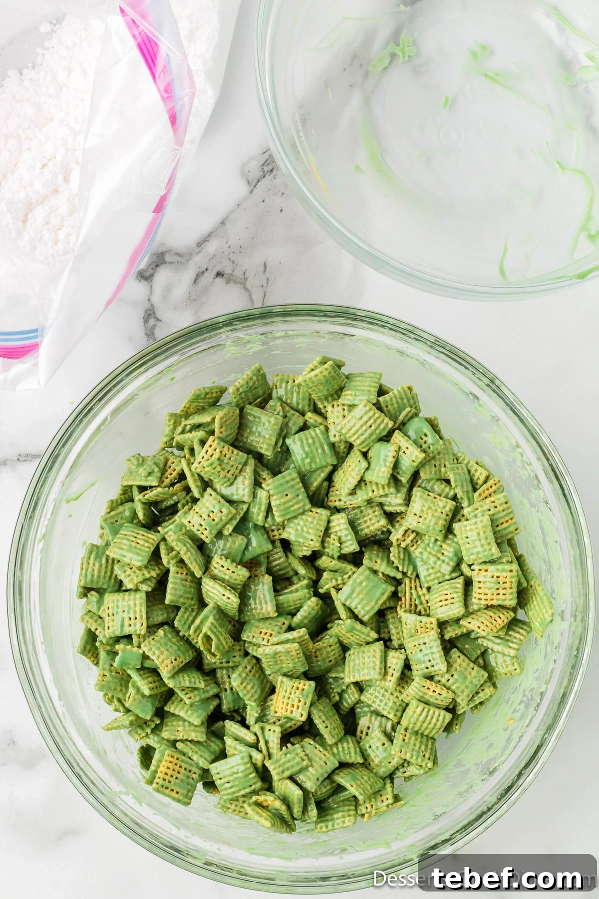 Grinch Puppy Chow Holiday Snack Mix Recipe 6 Cereal coated in candy mixture on a bowl.