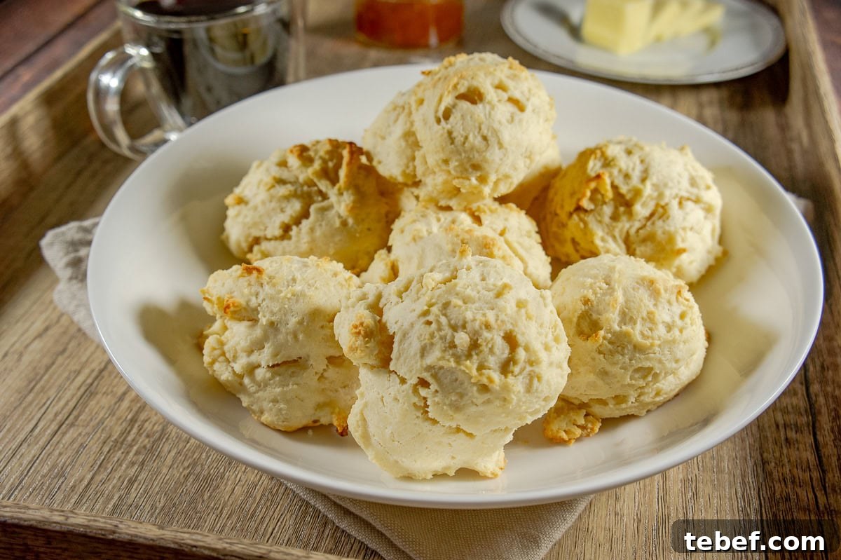 Flaky No-Knead Drop Biscuits Recipe for Quick Homemade Baking 6 a bowl of baked drop biscuits on a wooden serving tray.