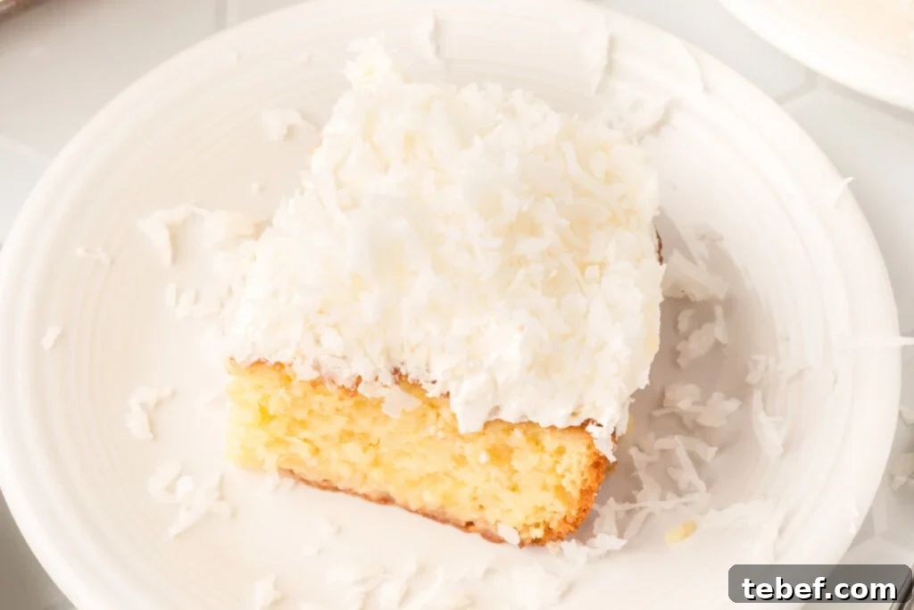Coconut Cream Poke Cake Recipe — Moist, Tropical Dessert 5 slice of coconut cream poke cake on plate