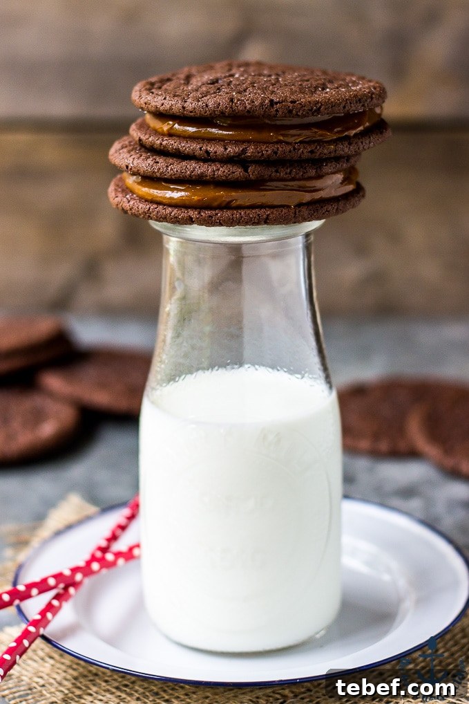 Mexican Chocolate Sandwich Cookies with Dulce de Leche Filling on top of a milk bottle