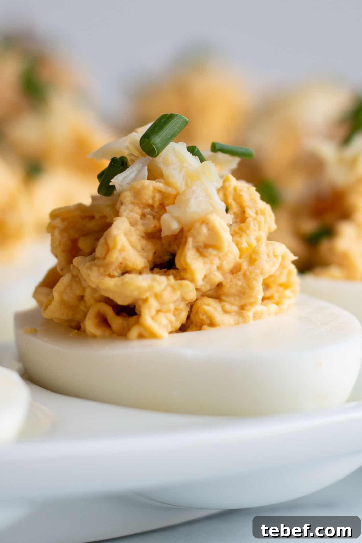 A deviled egg topped with fresh crab and chives.

