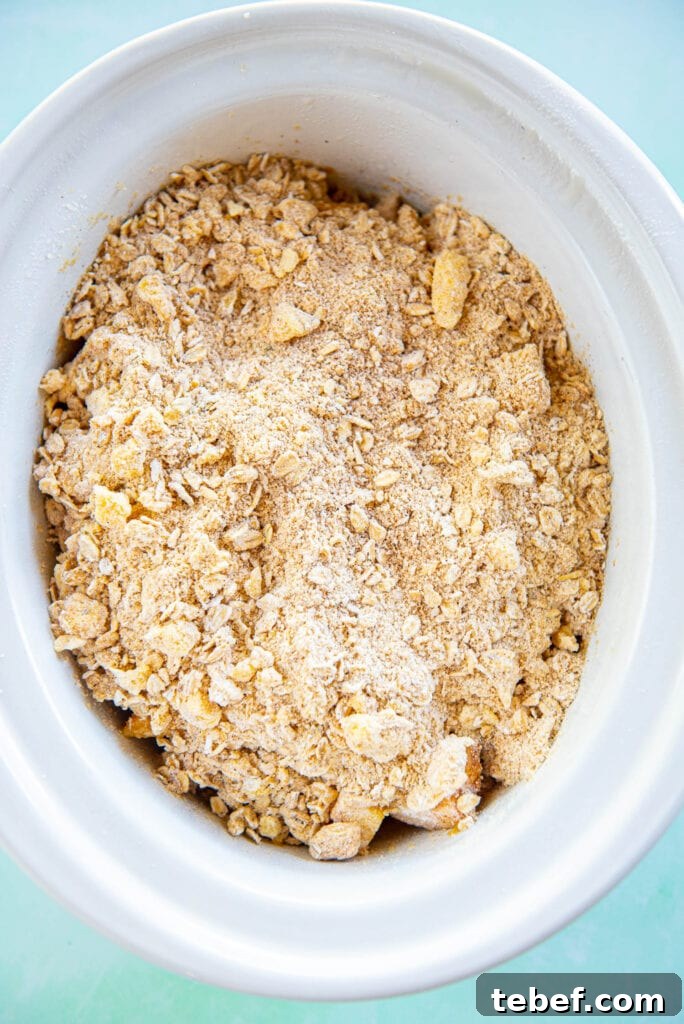 Slow Cooker Fresh Peach Cobbler Recipe with Homemade Topping 11 peach cobbler filling and topping in white slow cooker