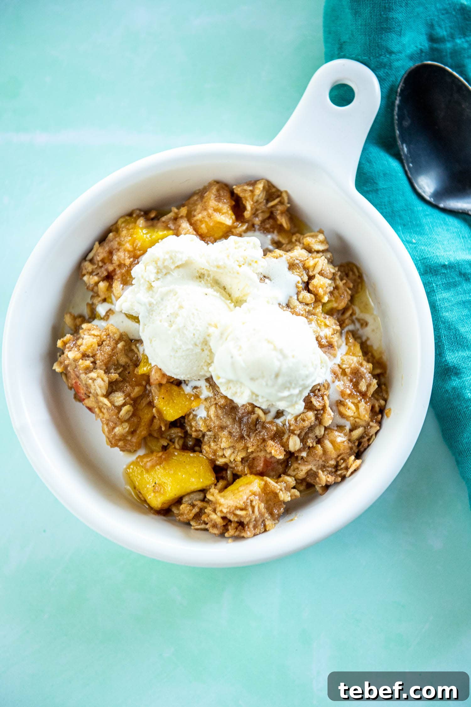 Slow Cooker Fresh Peach Cobbler Recipe with Homemade Topping 14 white ramekin with peach cobbler topped with ice cream