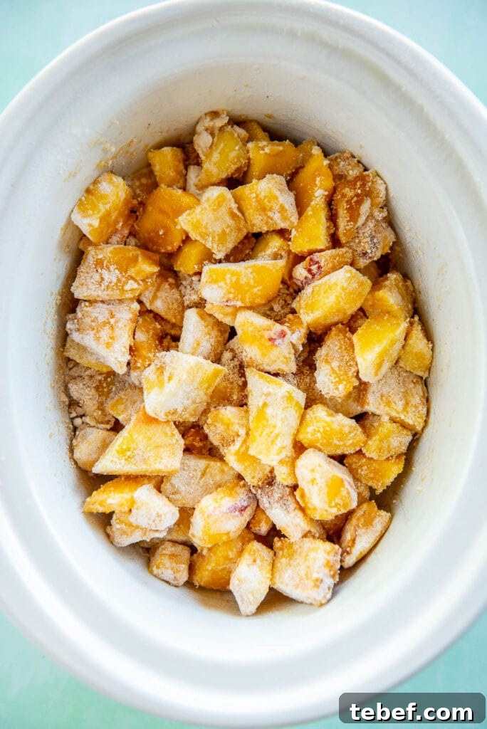 Slow Cooker Fresh Peach Cobbler Recipe with Homemade Topping 8 peach cobbler mixture in white slow cooker