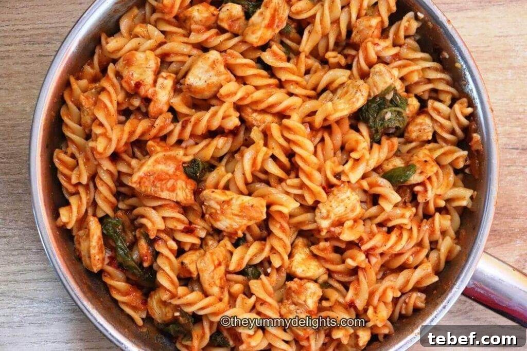 Creamy Tomato, Spinach & Chicken Pasta Recipe 3 top view of tomato spinach chicken pasta dish in the skillet.