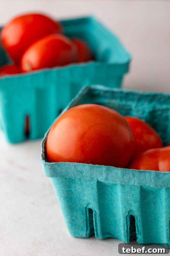 Creamy Sheet-Pan Roasted Tomato Soup Recipe 3 roma and regular tomatoes in blue containers