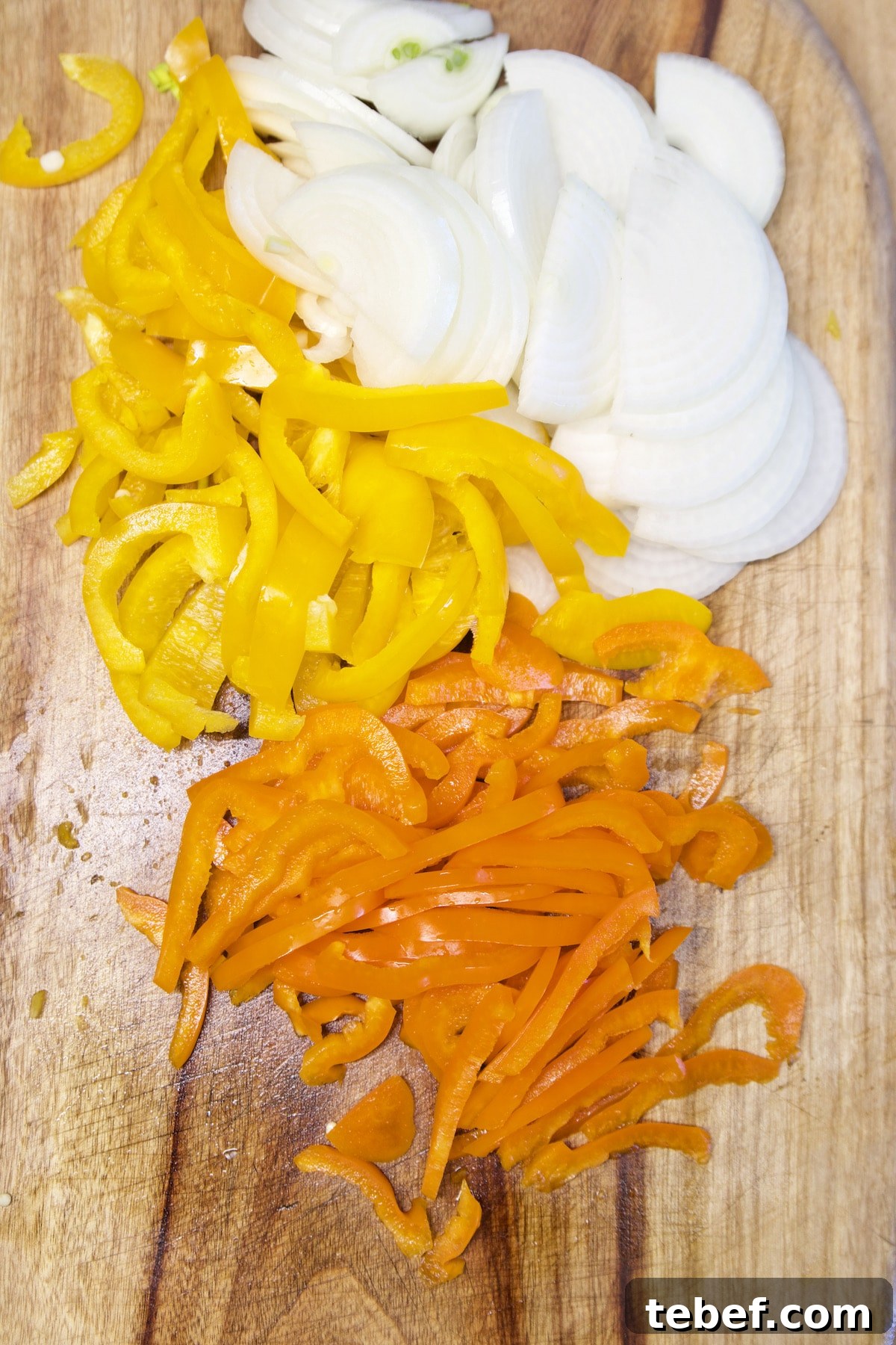 Sliced onions, yellow and orange bell peppers.