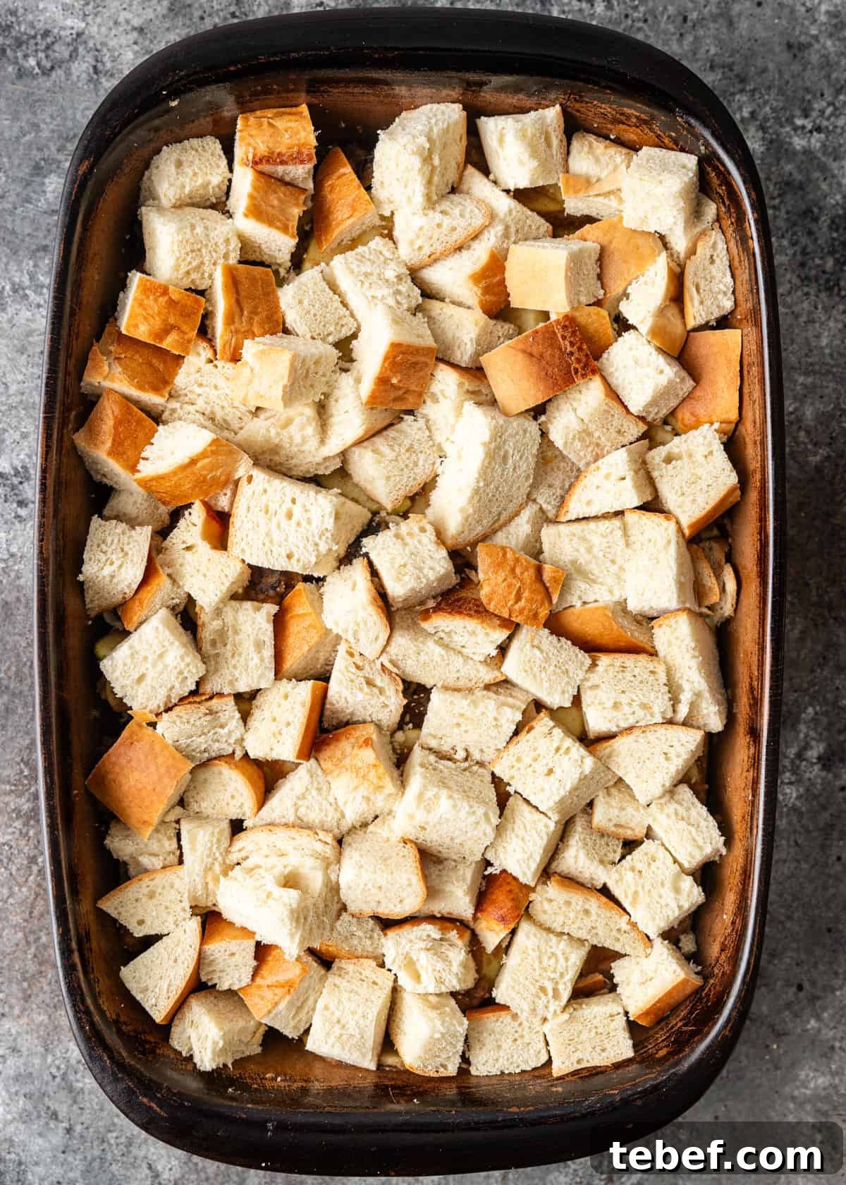 Mom’s Overnight French Toast Casserole Recipe for Busy Mornings 7 overhead: French toast casserole recipe assembled in a baking dish after adding bread
