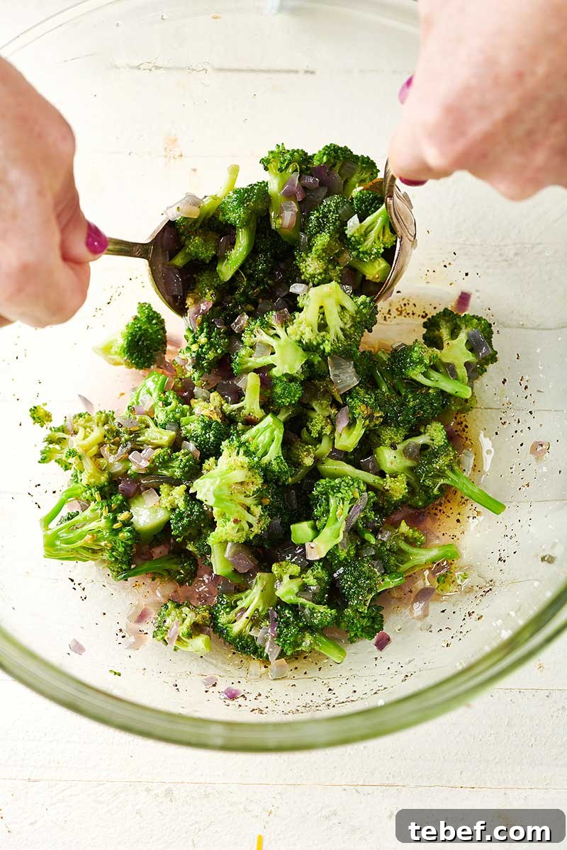 How to Trim, Chop, and Cook Broccoli for Perfect Results 11 Tossing Broccoli Orzo Salad with spoons.
