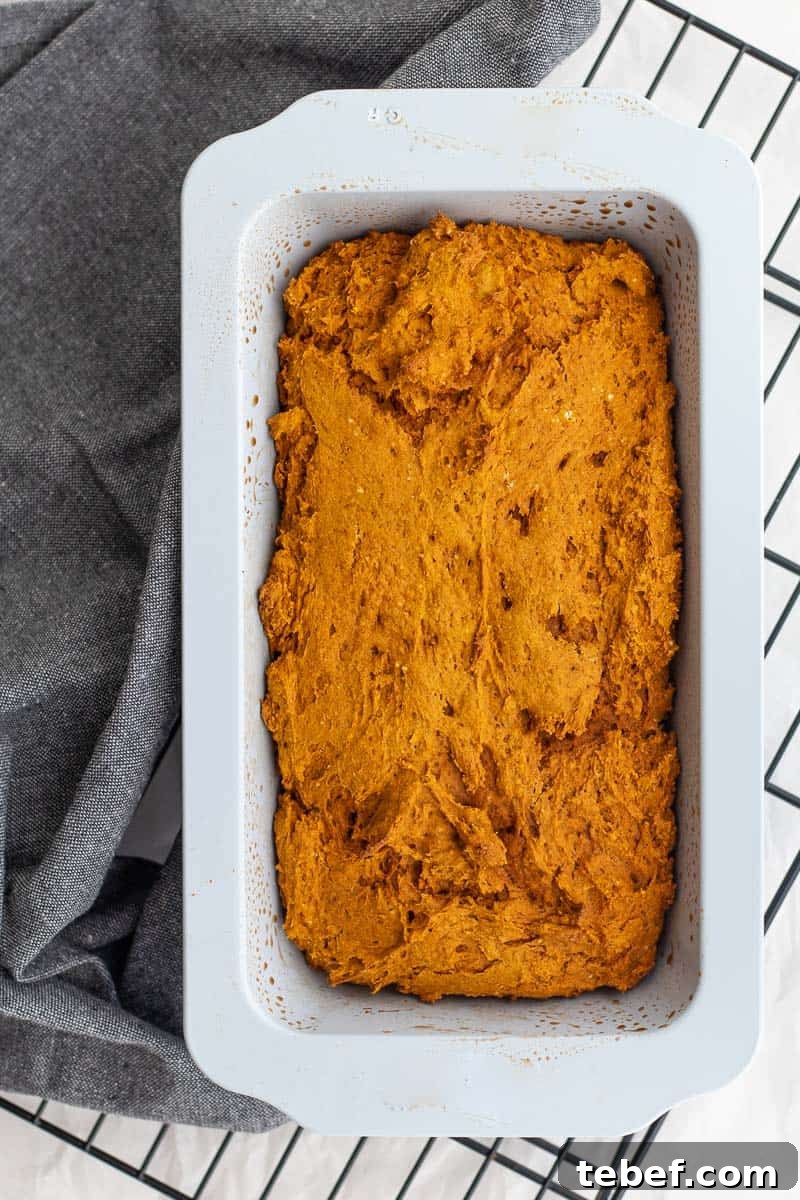Two-Ingredient Pumpkin Spice Cake Bread (From Spice Cake Mix) 8 pumpkin bread in a loaf pan on a cooling rack