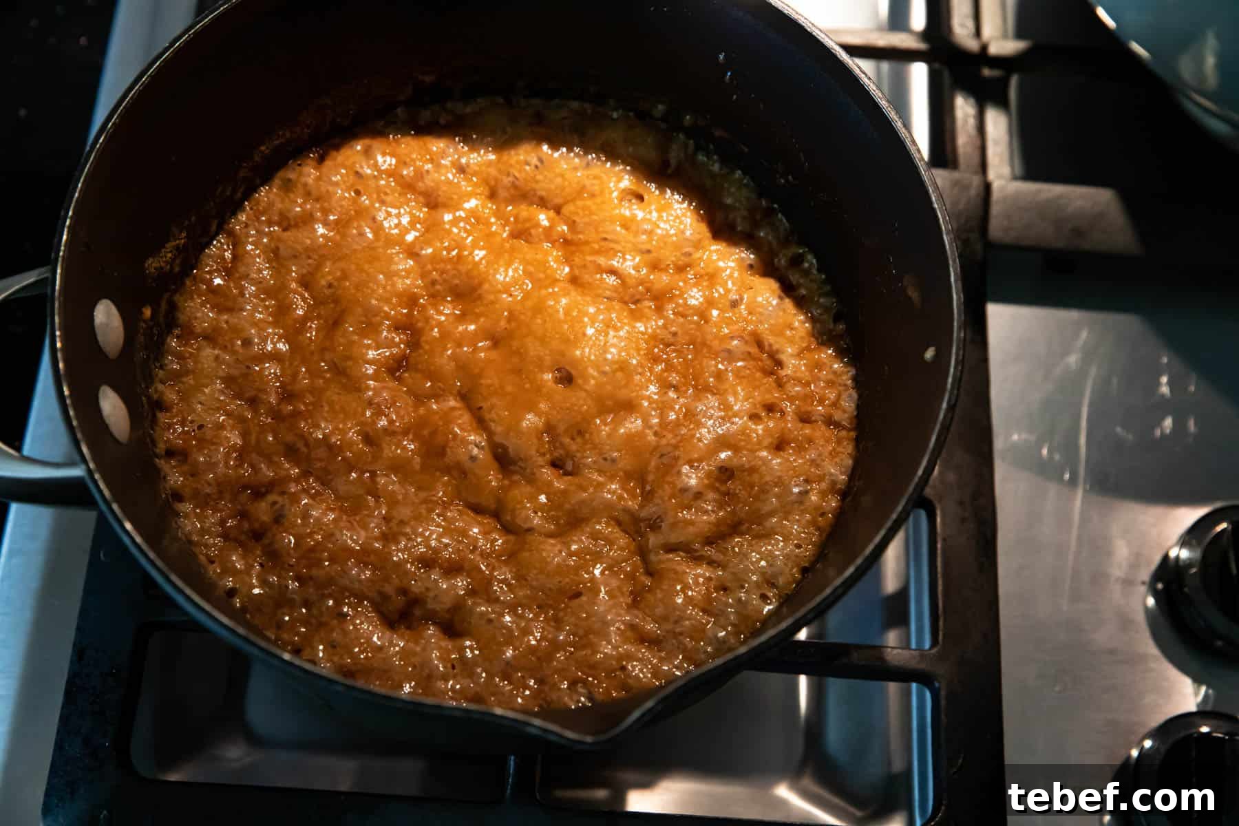 Saltine Toffee (Christmas Crack) — Sweet and Salty Holiday Candy 5 Pouring caramel over crackers