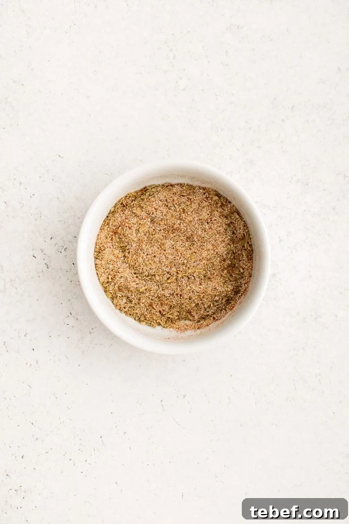 Perfect Oven-Roasted Pork Loin: Juicy, Crispy Recipe and Tips 3 A small bowl with a vibrant spice mix of garlic powder, onion powder, thyme, paprika, salt, and pepper, ready to be rubbed onto the pork roast.