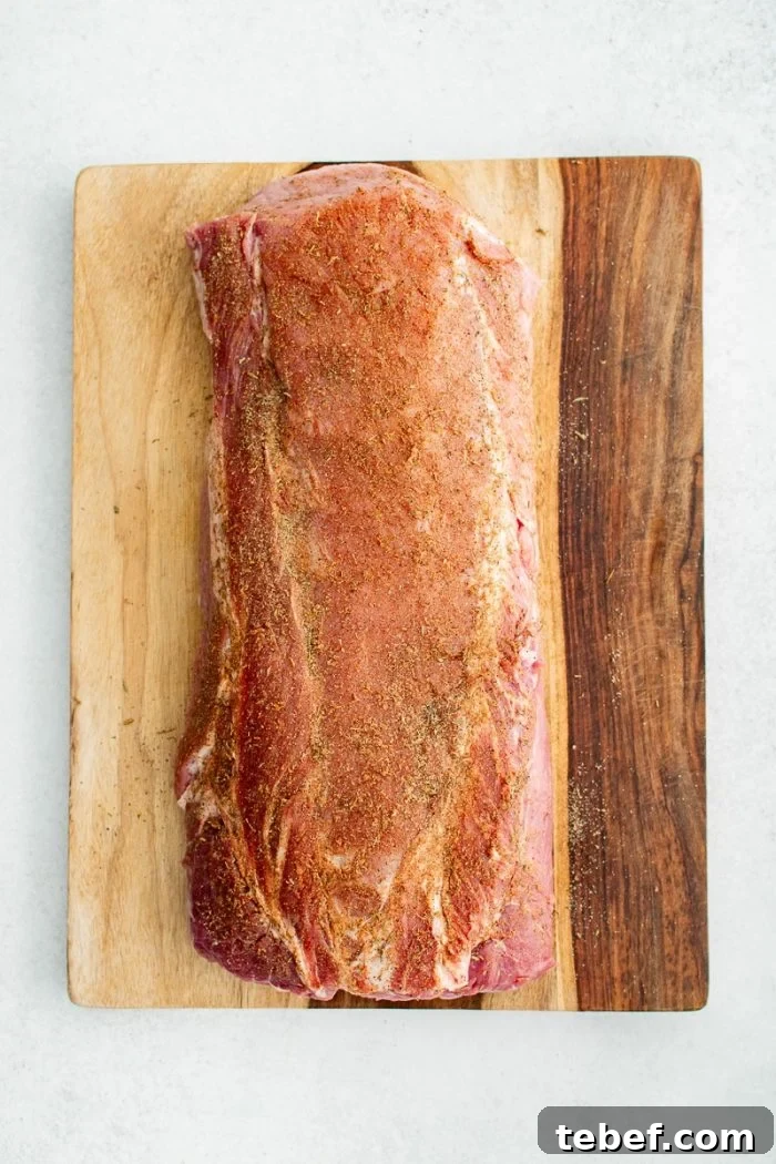 Perfect Oven-Roasted Pork Loin: Juicy, Crispy Recipe and Tips 4 Pork loin roast on a large wooden cutting board coated in a homemade dry spice rub.