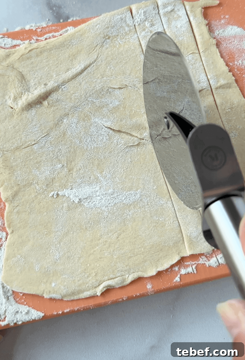Cutting the dough into strips with a pizza cutter