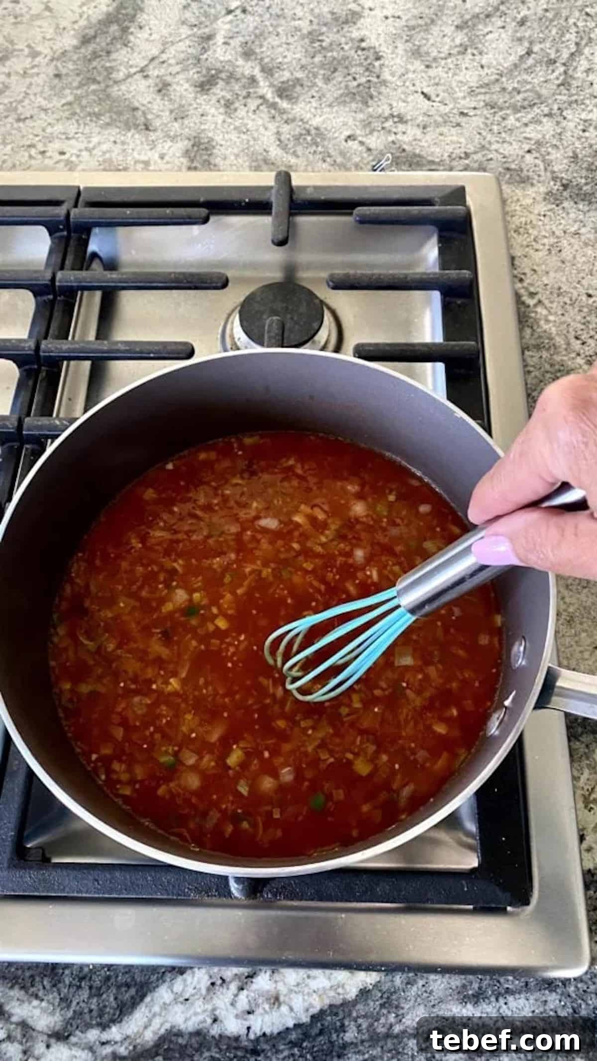 I am whisking the tomato paste into the onion mixture.