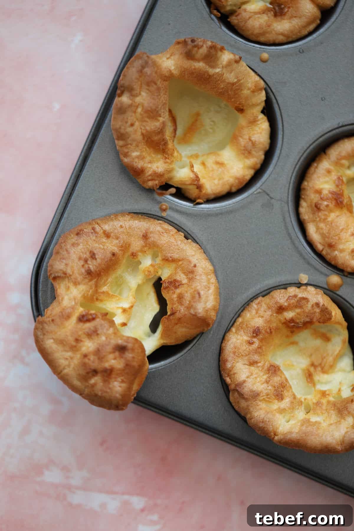 Close up of a gluten free Yorkshire pudding in a baking tin.