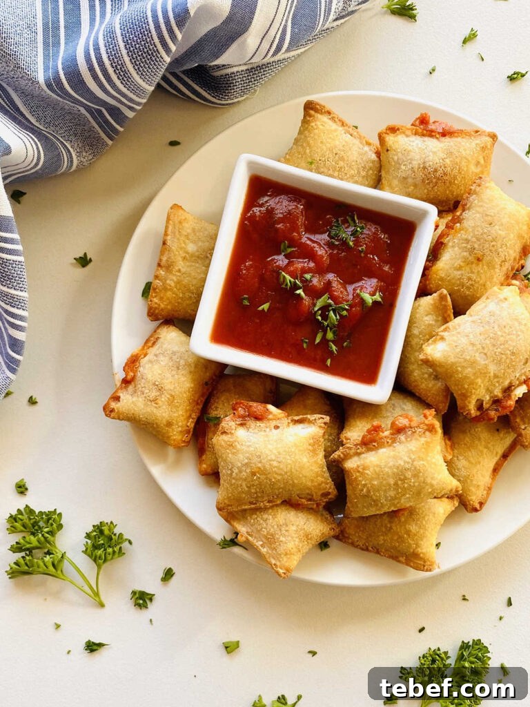 Air fryer pizza rolls on plate next to dish of marinara dipping sauce