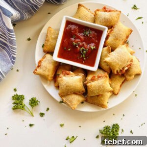 Air fryer pizza rolls on plate next to dish of marinara dipping sauce