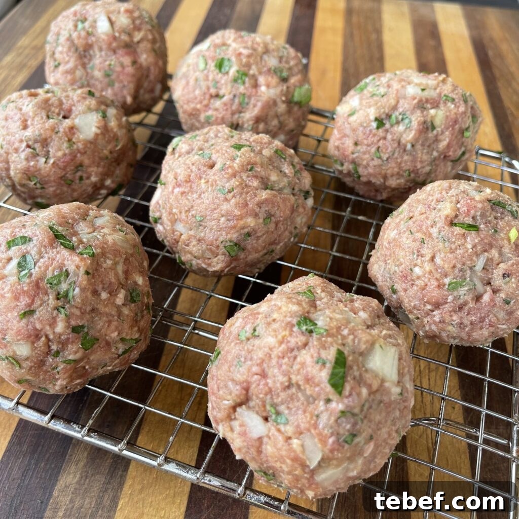 Raw homemade meatballs on a rack