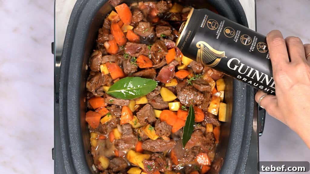 adding Guinness into a beef stew cooking in a crock pot