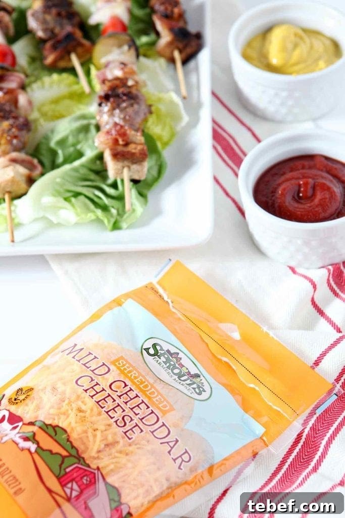 A bag of Sprouts Shredded Mild Cheddar Cheese is highlighted with the entree and dips in the background