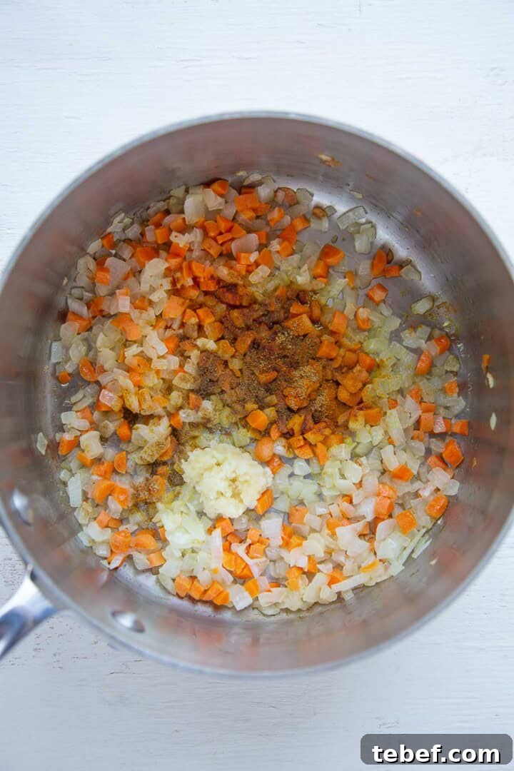 onions, carrots, and spices in a pot.